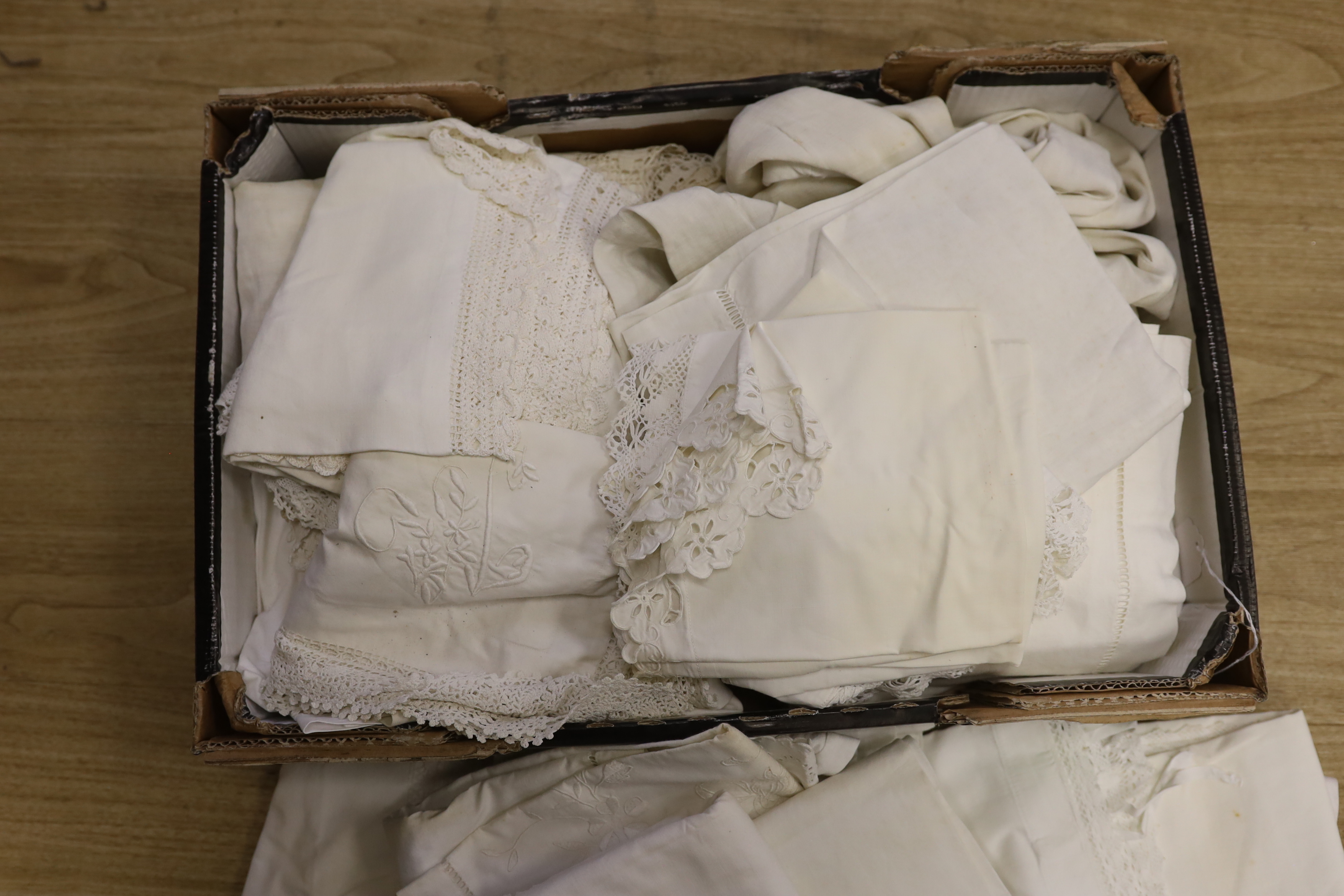 A large collection of French embroidered and crochet edged pillowcases and bolsters, some in pairs